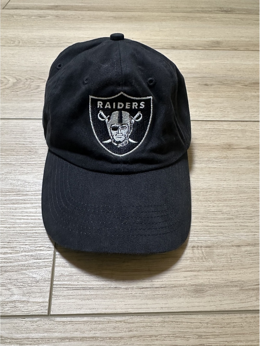 Raiders Black Baseball Cap with Embroidered Logo and 'Commitment to Excellence'